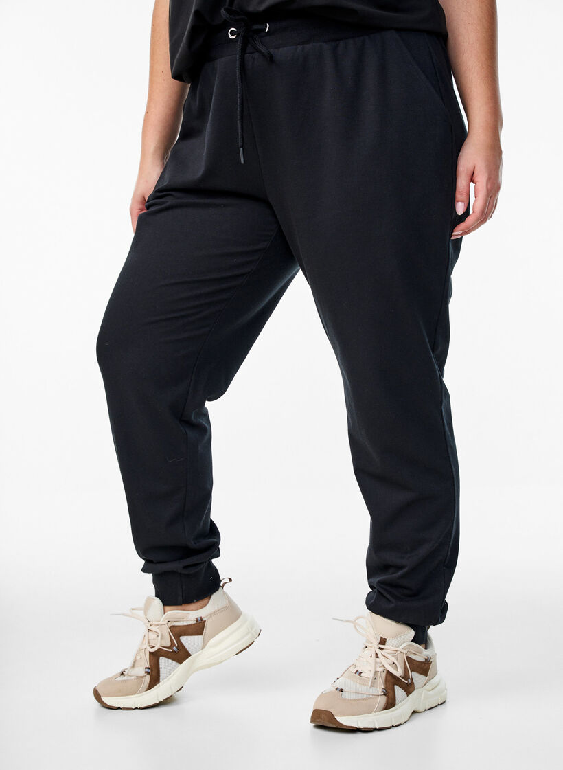Loose workout trousers with pockets, Black, Model image number 0